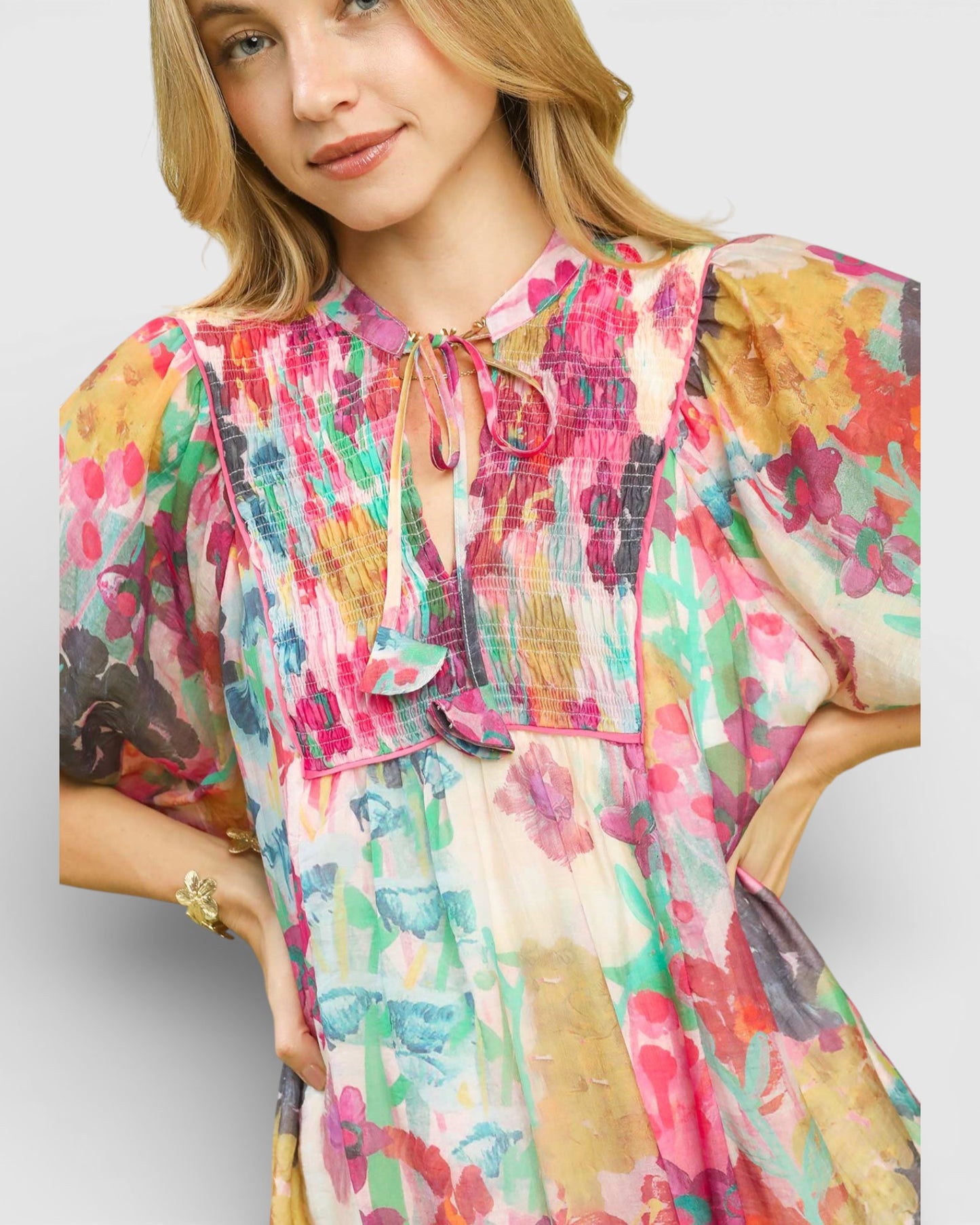 Woman wearing a colorful floral dress on a light gray background