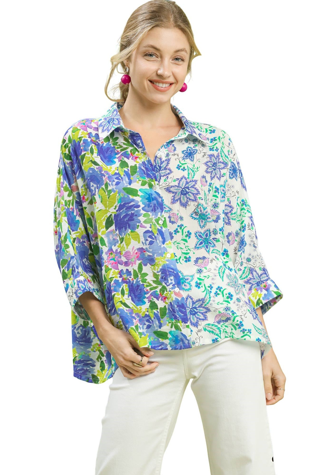 Woman wearing a colorful floral blouse with white pants on a white background