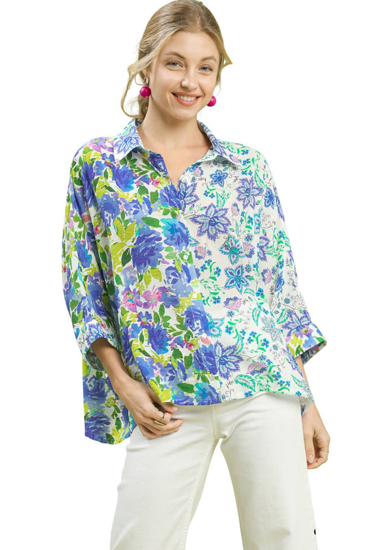 Woman wearing a colorful floral blouse with white pants on a white background