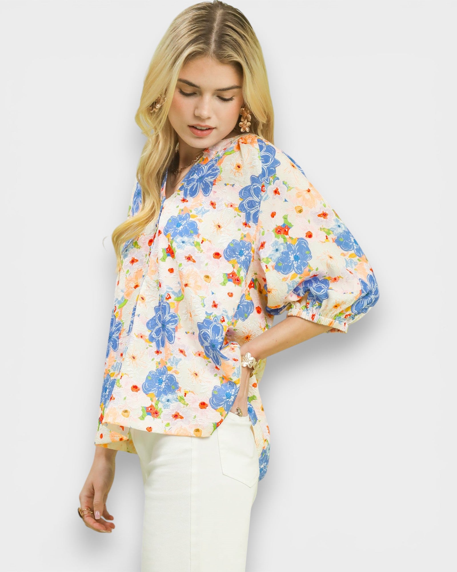 Woman wearing a colorful floral blouse against a white background