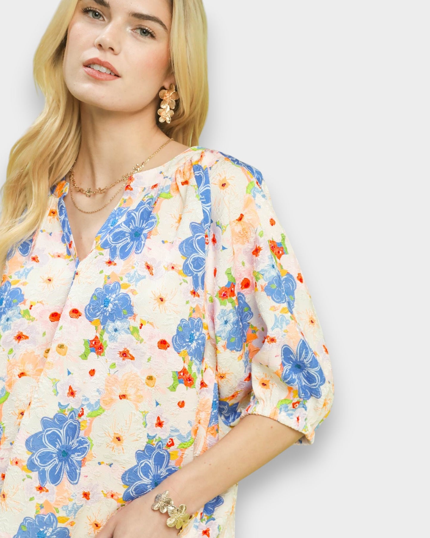 Woman wearing a colorful floral dress on a light background
