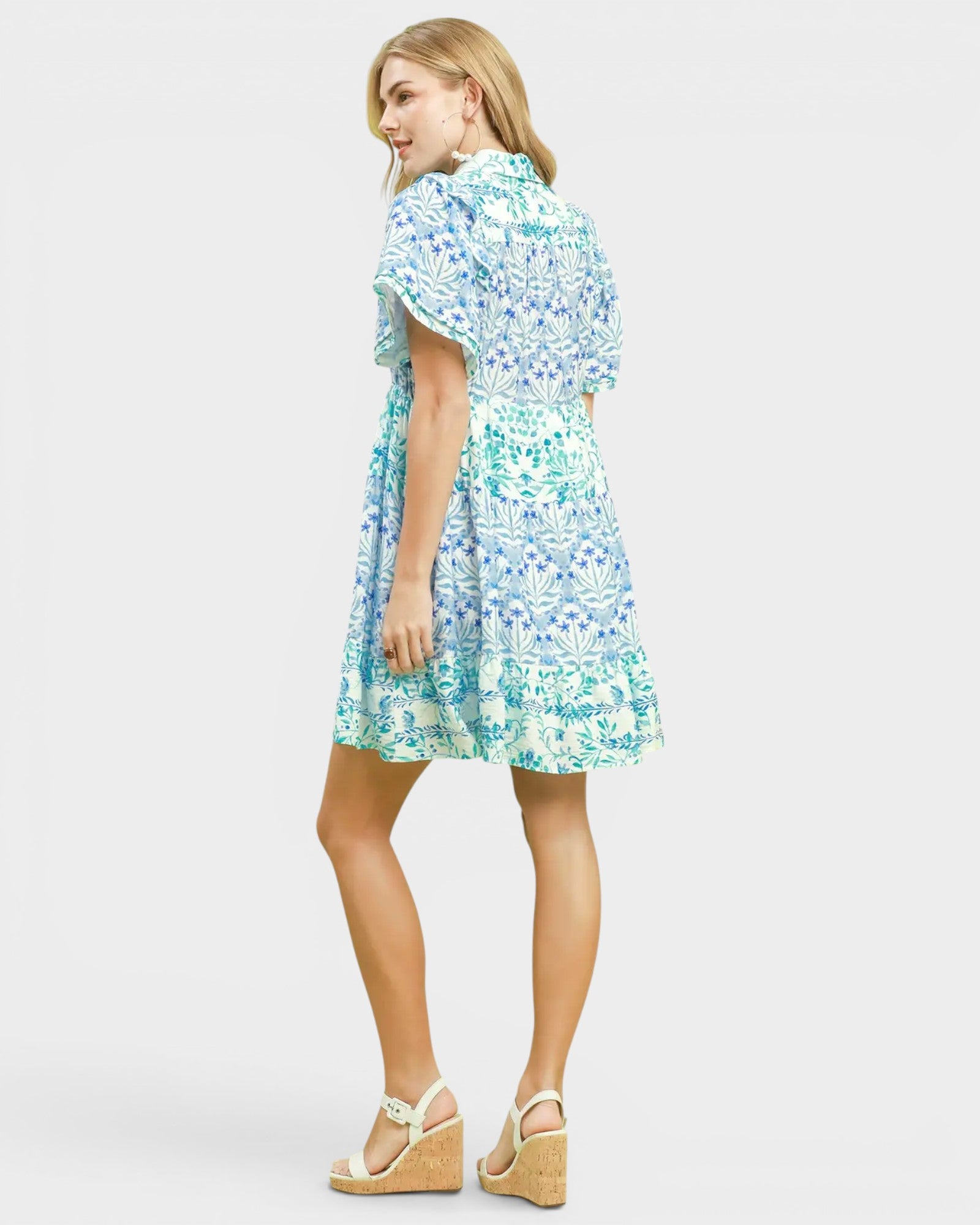 Woman wearing a floral dress on a plain background