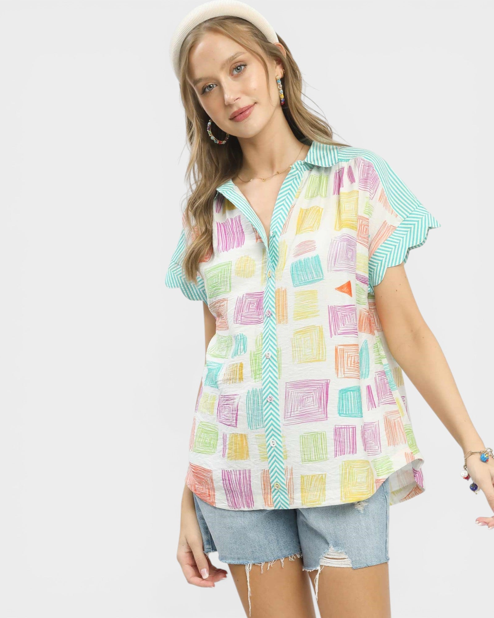 Woman wearing a colorful patterned shirt with a plain background