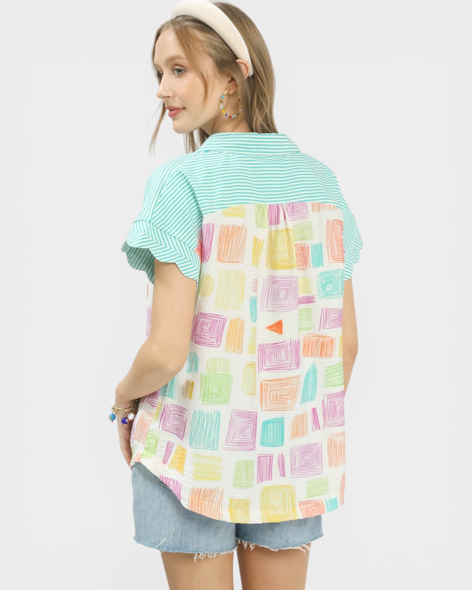 Person wearing a colorful patterned shirt over a green base shirt on a white background