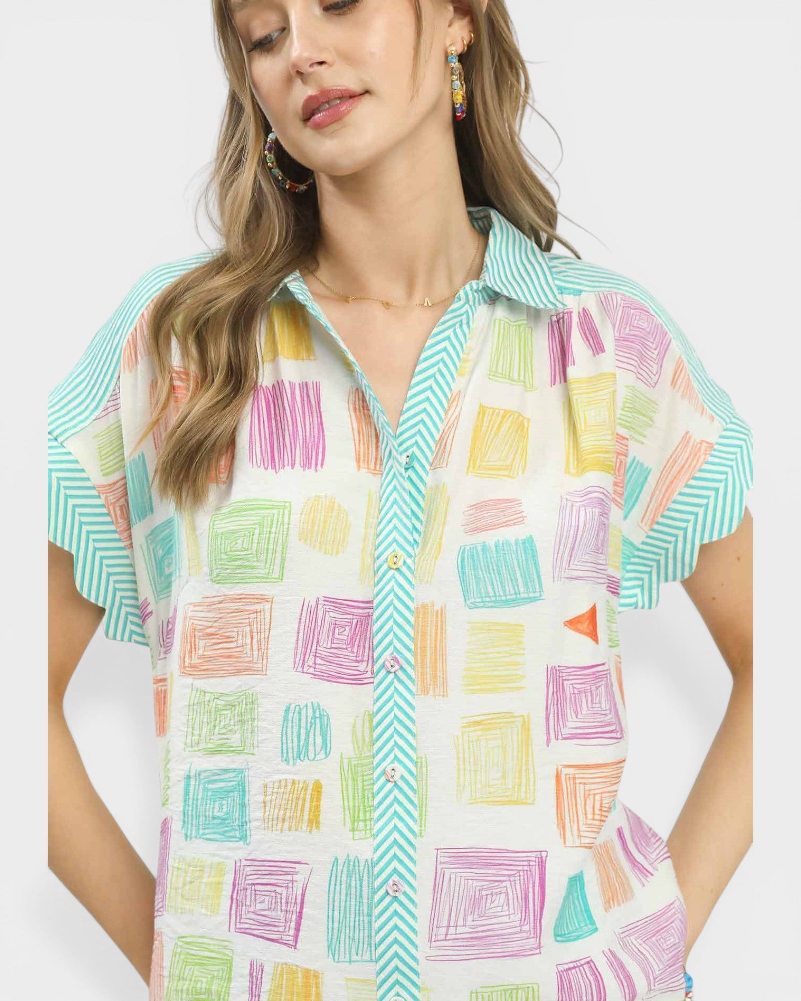 Woman wearing a colorful geometric patterned shirt on a white background