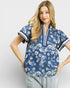 Woman wearing a blue floral blouse with a white background