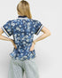 Woman wearing a blue floral blouse with white background