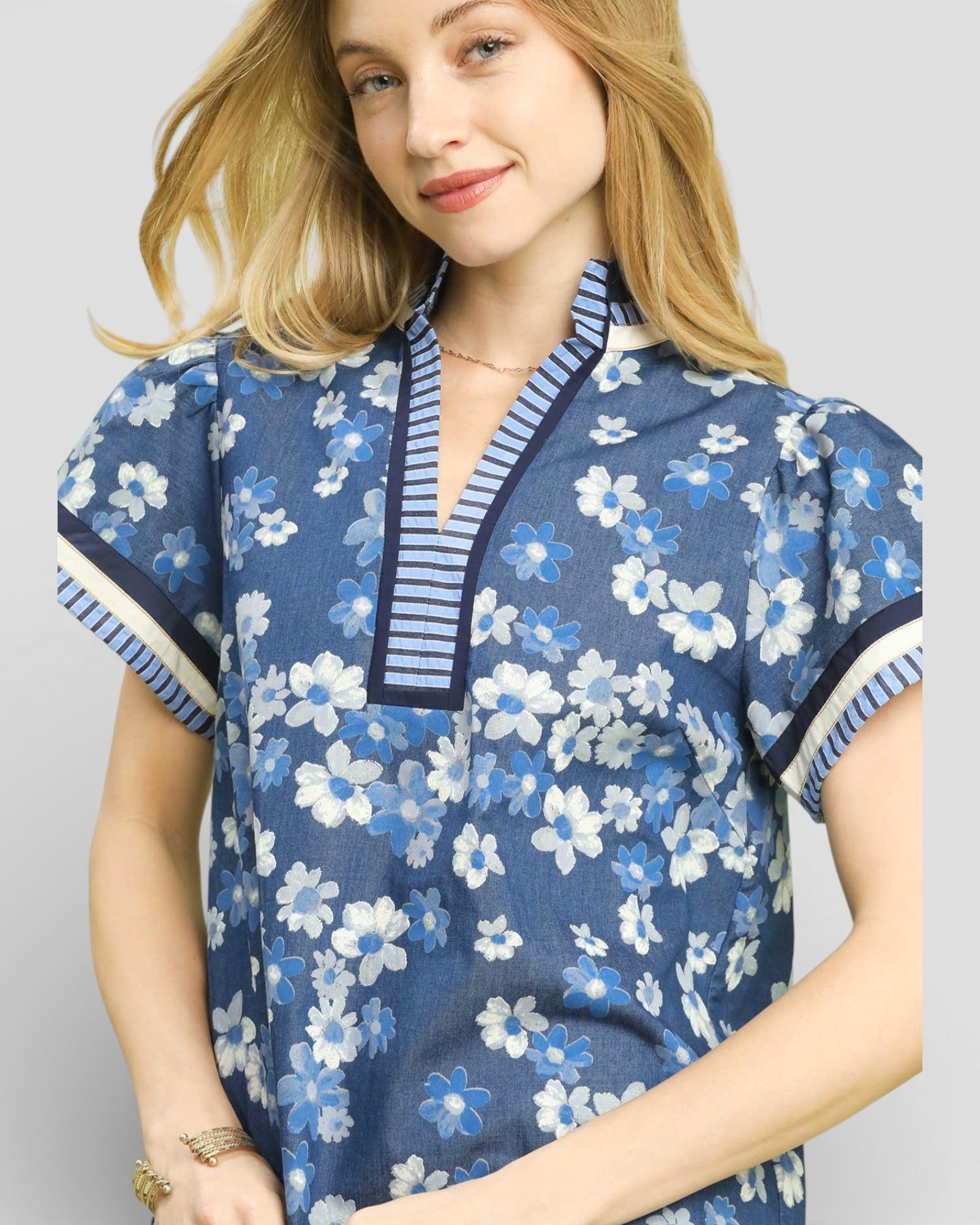 Woman wearing a blue floral dress with a white background