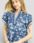 Woman wearing a blue floral dress with a white background