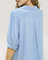 Light blue blouse worn by a person on a plain background