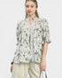 Woman wearing a floral blouse with a plain background