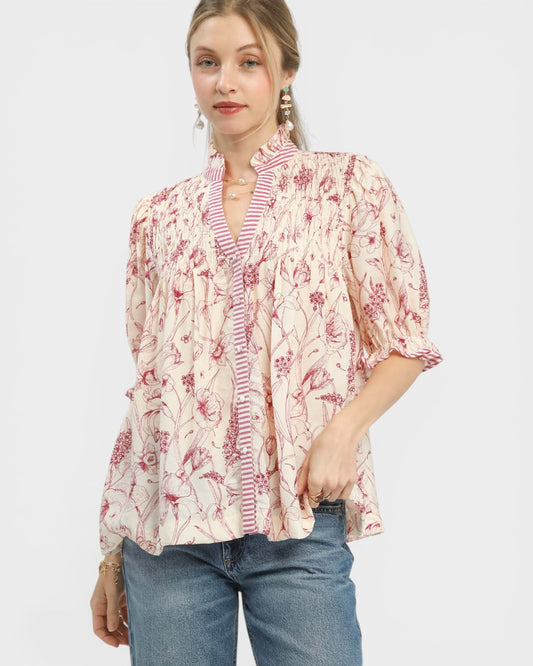 Woman wearing a floral blouse with a plain background