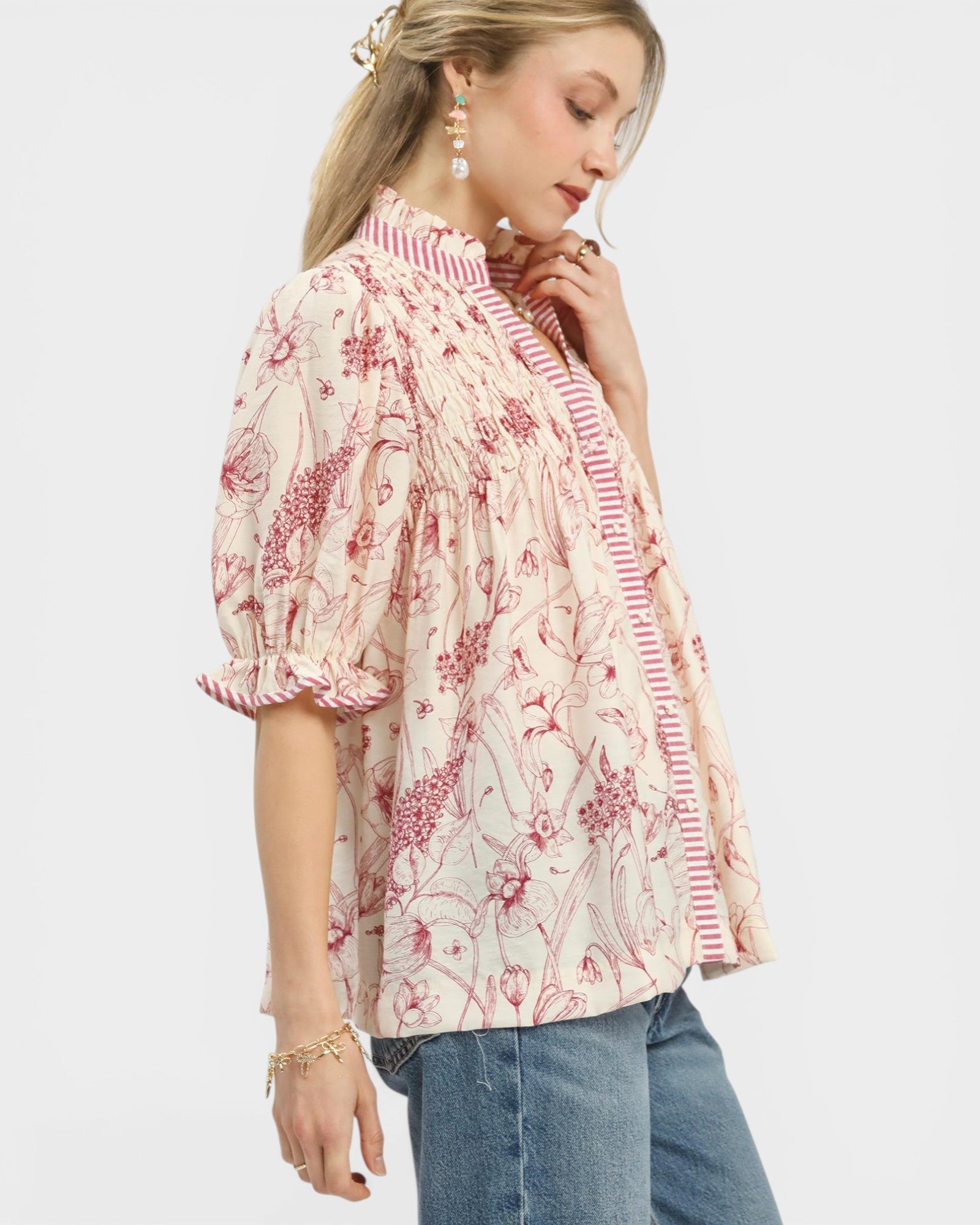 Woman wearing a floral blouse with ruffled sleeves on a white background