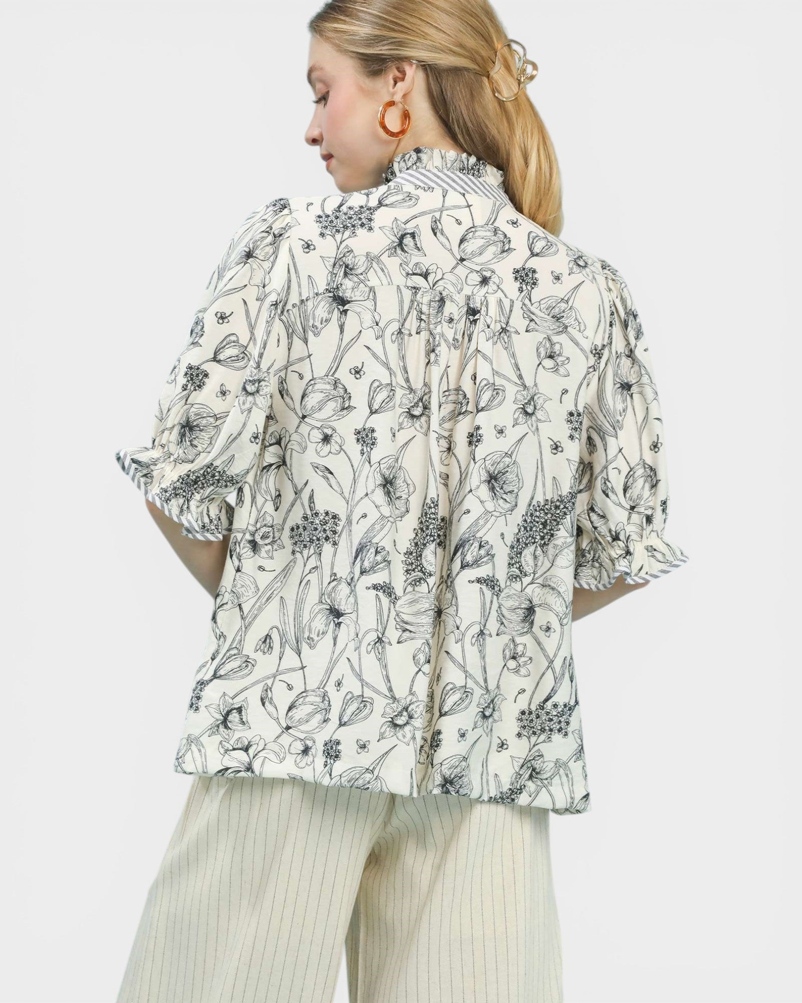 Woman wearing a floral patterned blouse with a plain background