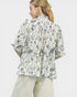 Woman wearing a floral patterned blouse with a plain background