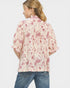 Woman wearing a floral blouse with puffed sleeves on a white background
