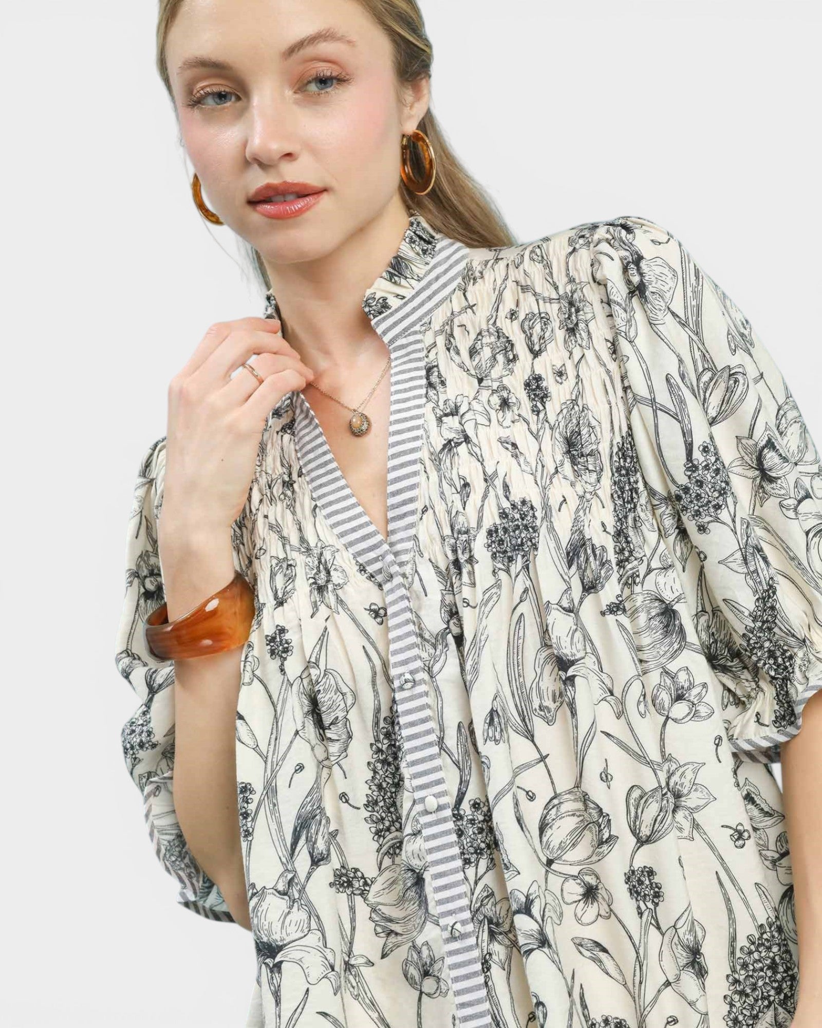 Woman wearing a floral kimono-style garment on a plain background