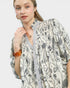 Woman wearing a floral kimono-style garment on a plain background