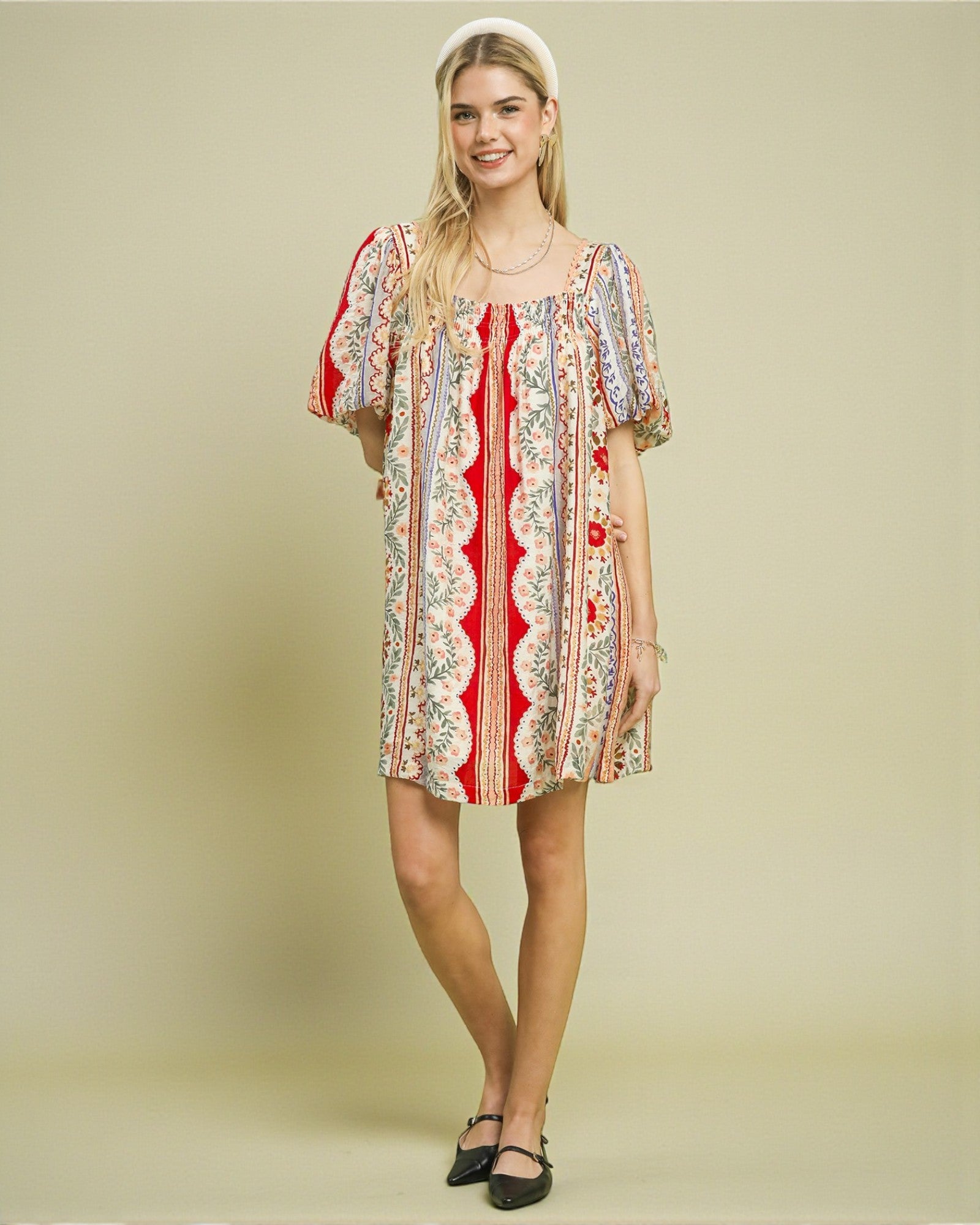 Woman wearing a patterned dress on a beige background