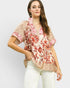 Woman wearing a floral blouse with a plain background