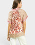 Woman wearing a floral blouse with a plain background