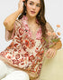 Woman wearing a floral kimono-style top holding flowers against a white background