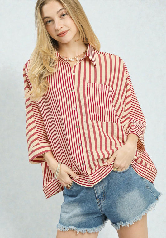 Woman wearing a red and white striped shirt and denim shorts on a plain background