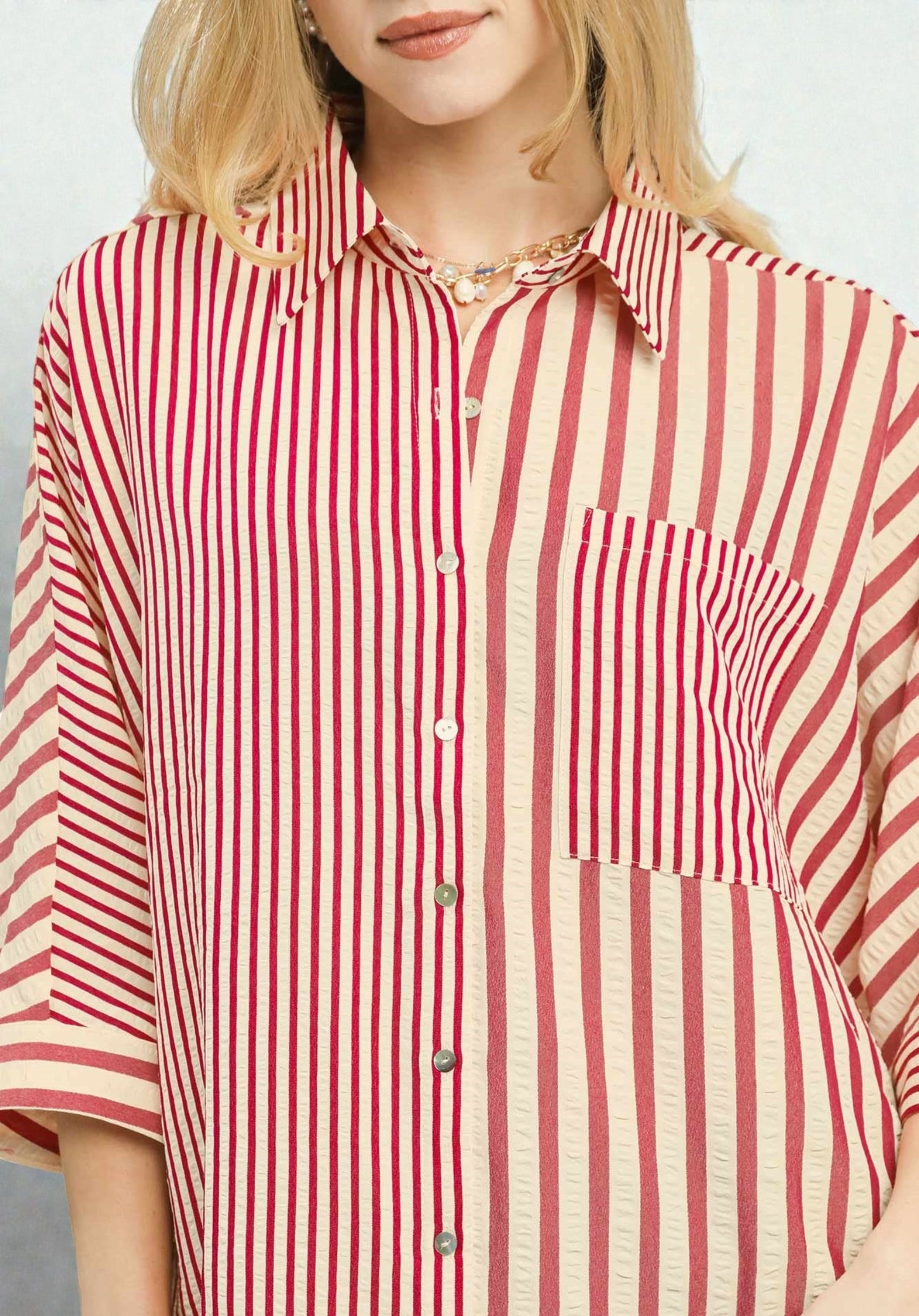 Red and white striped shirt worn by a person on a plain background