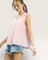 Woman wearing a red and white striped sleeveless top and denim shorts on a light gray background