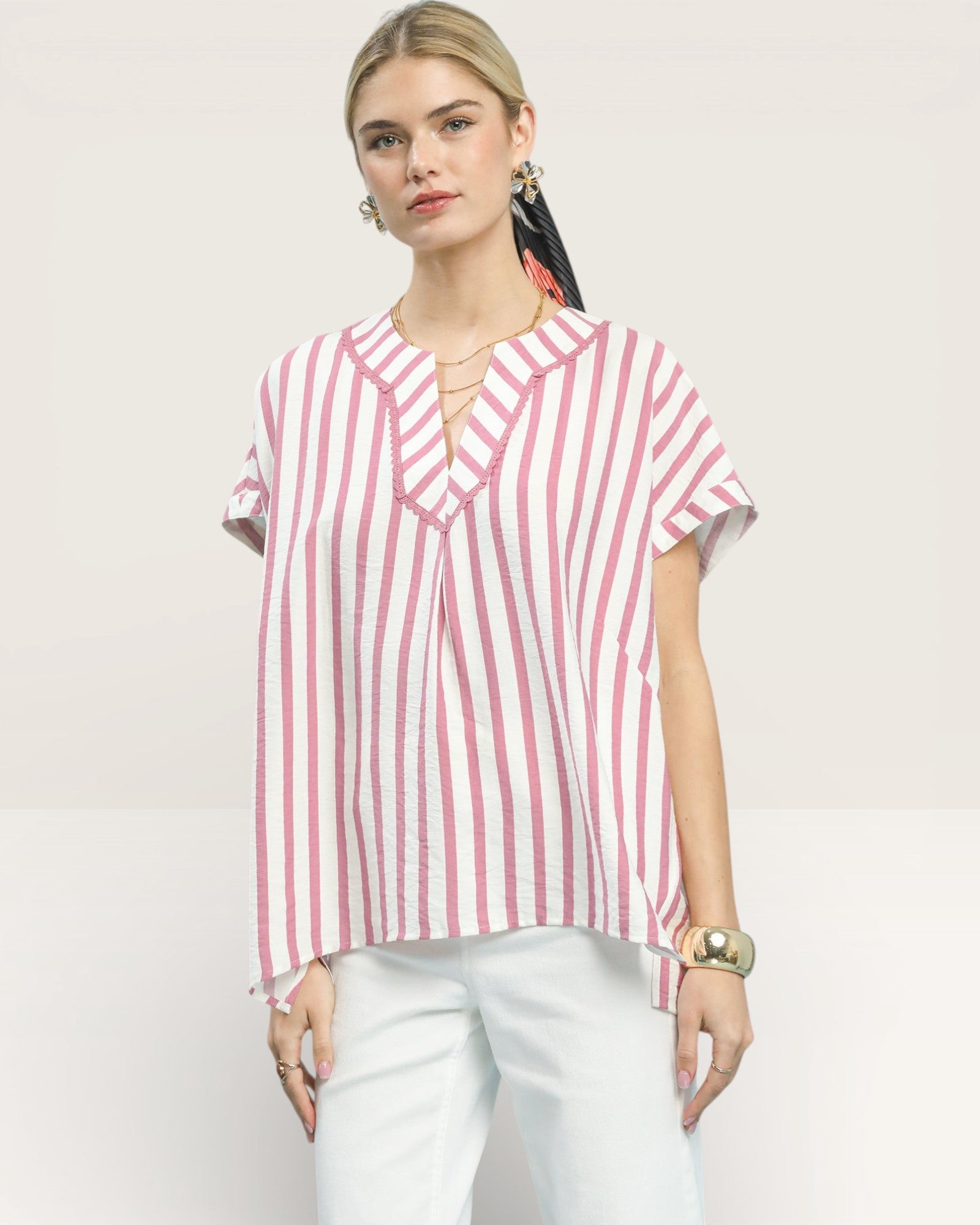 Woman wearing a red and white striped shirt on a light pink background