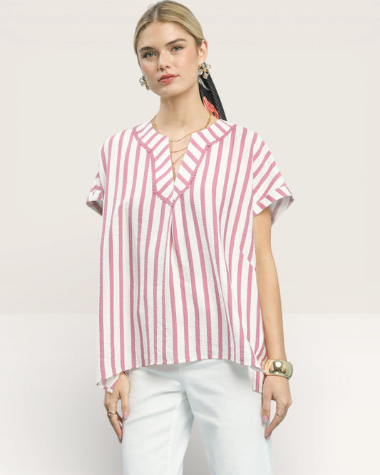 Woman wearing a red and white striped shirt on a light pink background