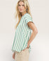 Woman wearing a green and white striped shirt on a plain background
