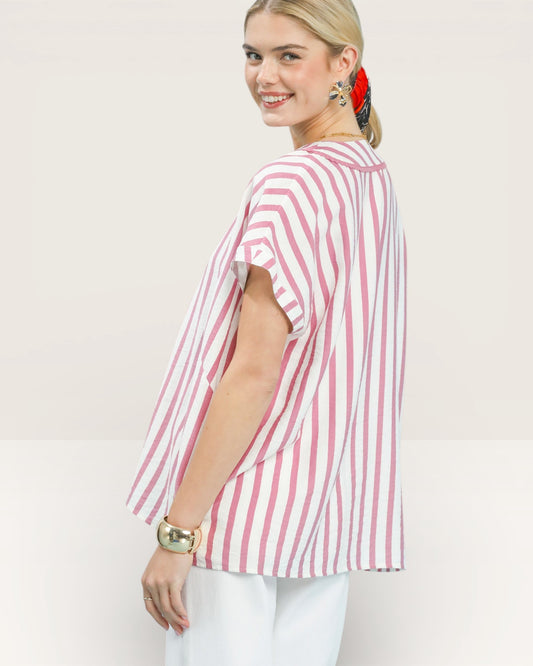 Woman wearing a pink and white striped shirt against a plain background