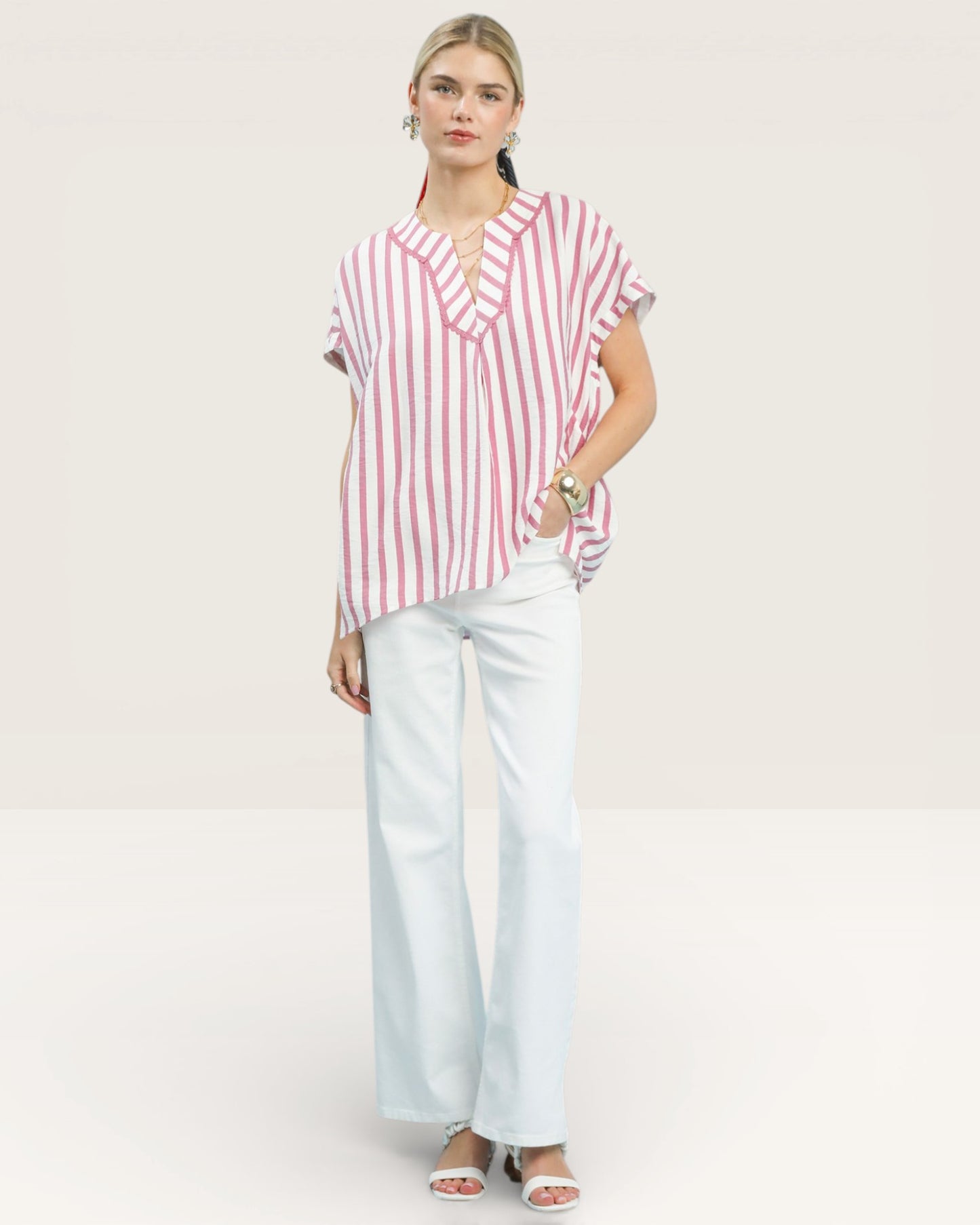 Woman wearing a red and white striped shirt and light blue pants on a white background