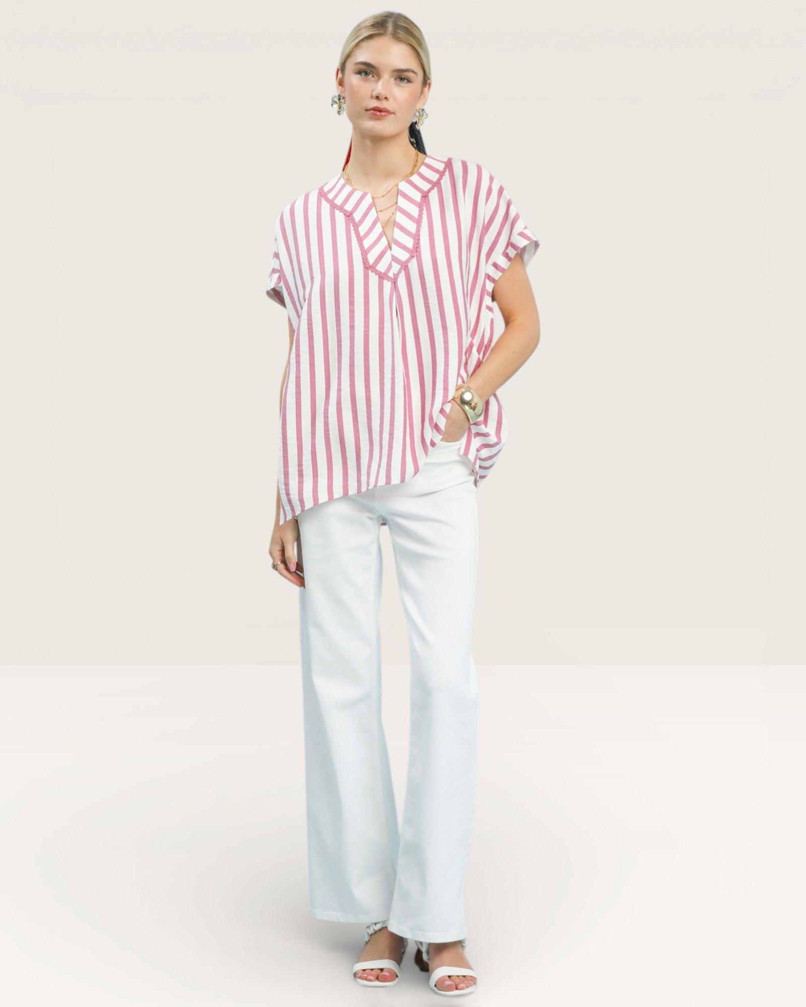 Woman wearing a red and white striped shirt and light blue pants on a white background