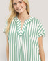 Woman wearing a green and white striped shirt against a plain background