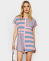 Woman wearing a pink and blue striped romper on a white background