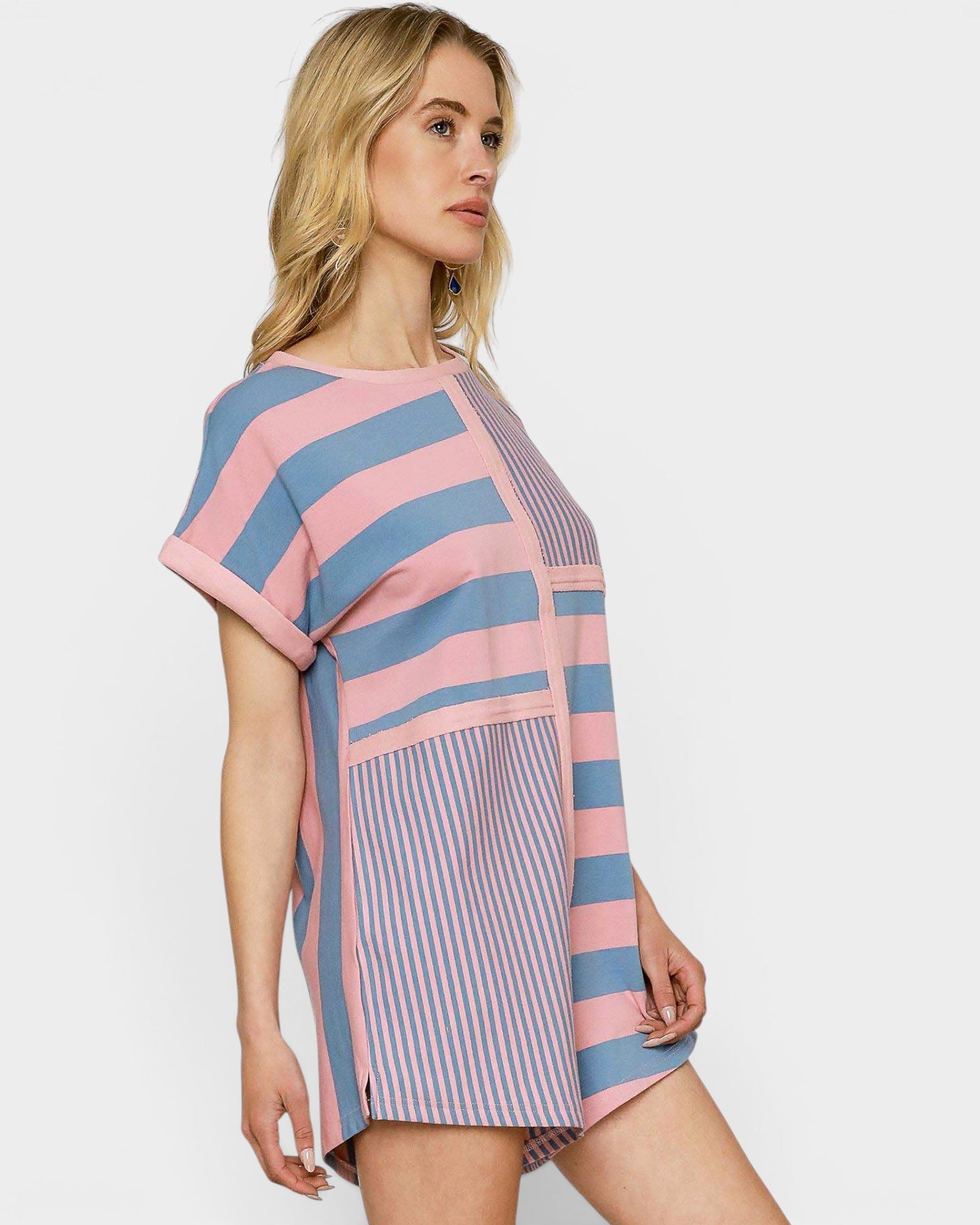 Woman wearing a pink and blue striped romper on a white background