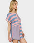 Woman wearing a pink and blue striped romper on a white background