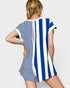 Woman wearing a blue and white striped romper with on a plain background