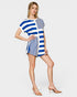 Woman wearing a blue and white striped romper with on a plain background