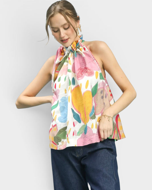 Woman wearing a colorful floral top with a plain background