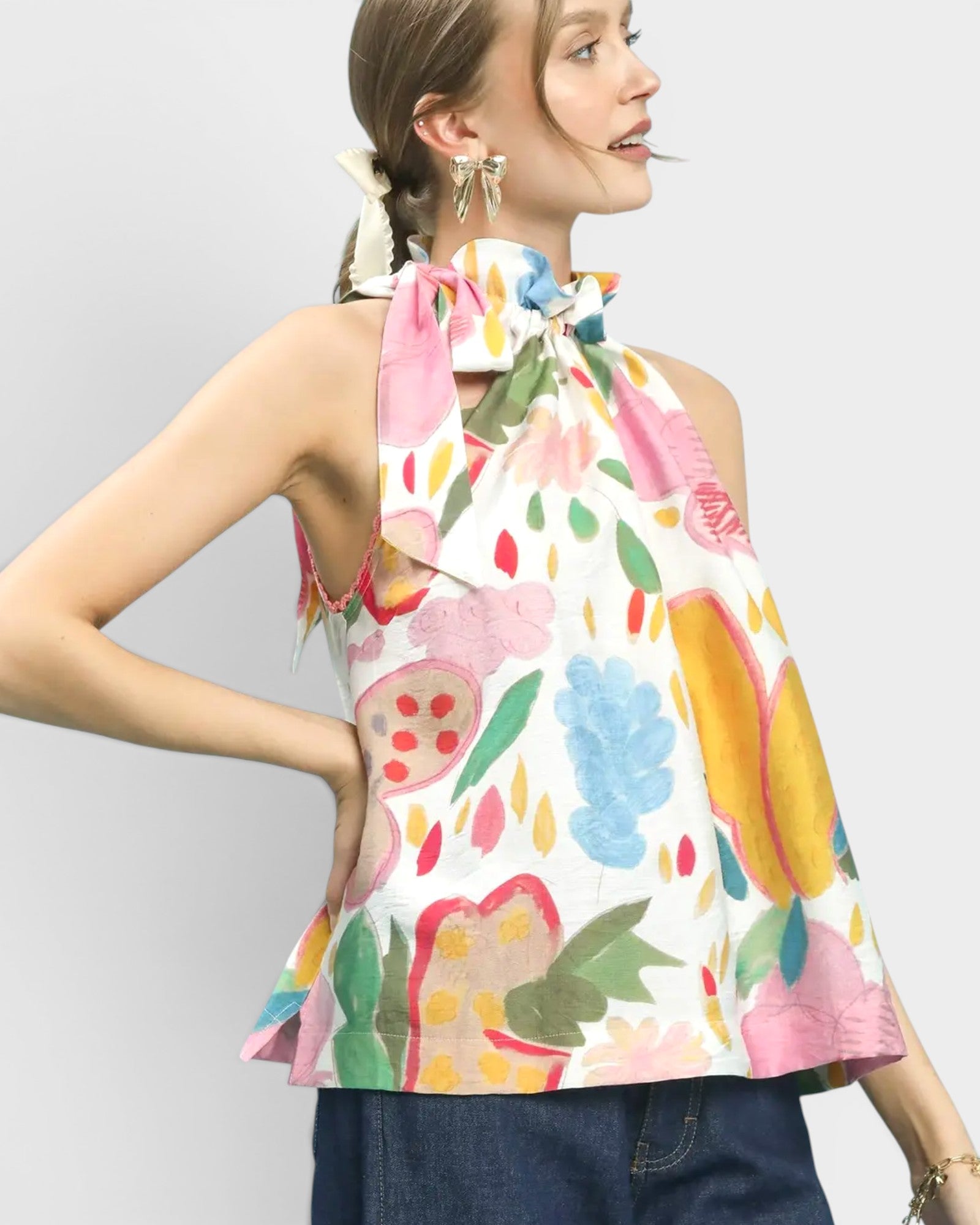 Woman wearing a colorful floral top with a plain background