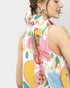 Woman wearing a colorful blouse with abstract patterns on a plain background