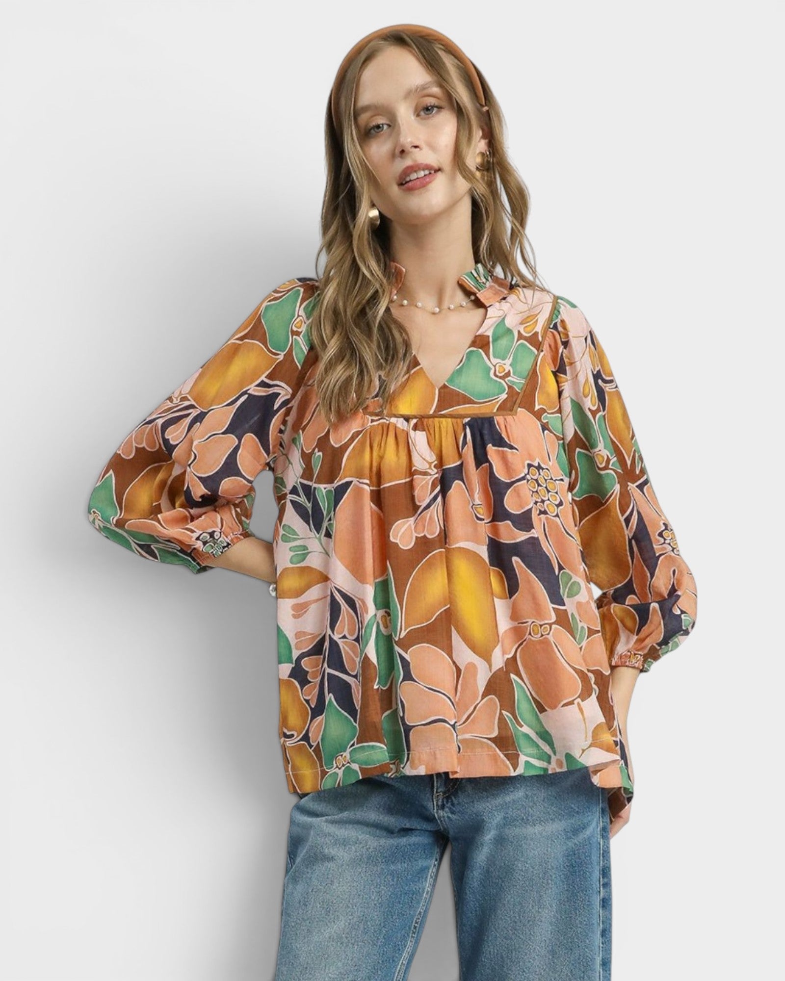 Woman wearing a floral blouse with a plain background