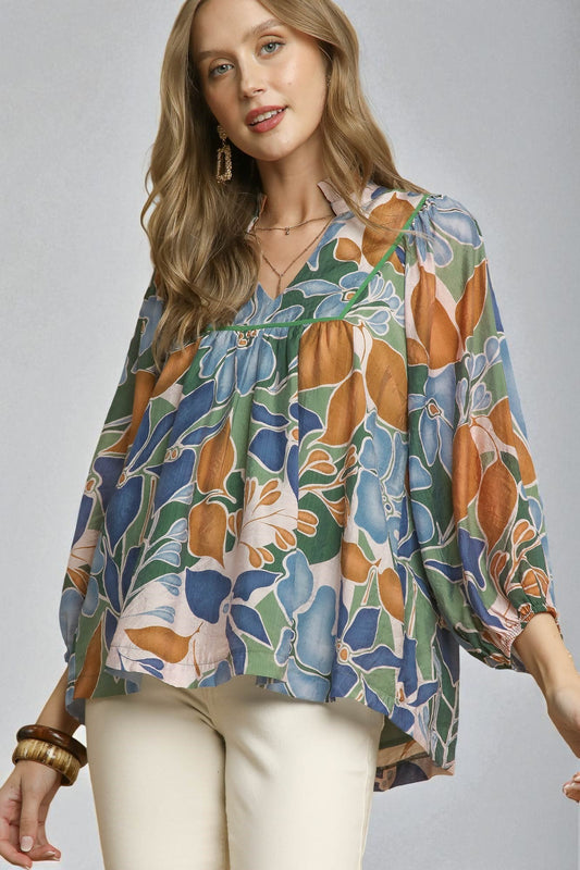 Woman wearing a floral patterned blouse against a plain background