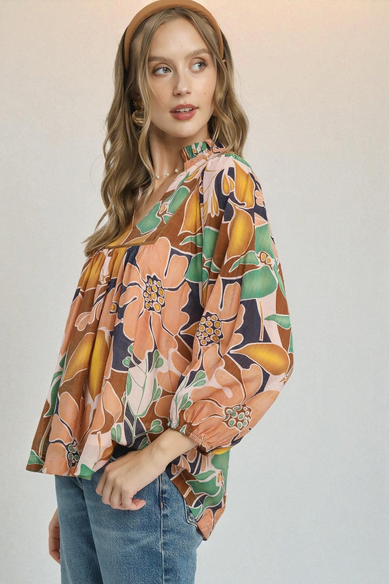 Woman wearing a floral blouse with a plain background