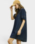 Woman wearing a navy dress and beige cap on a white background