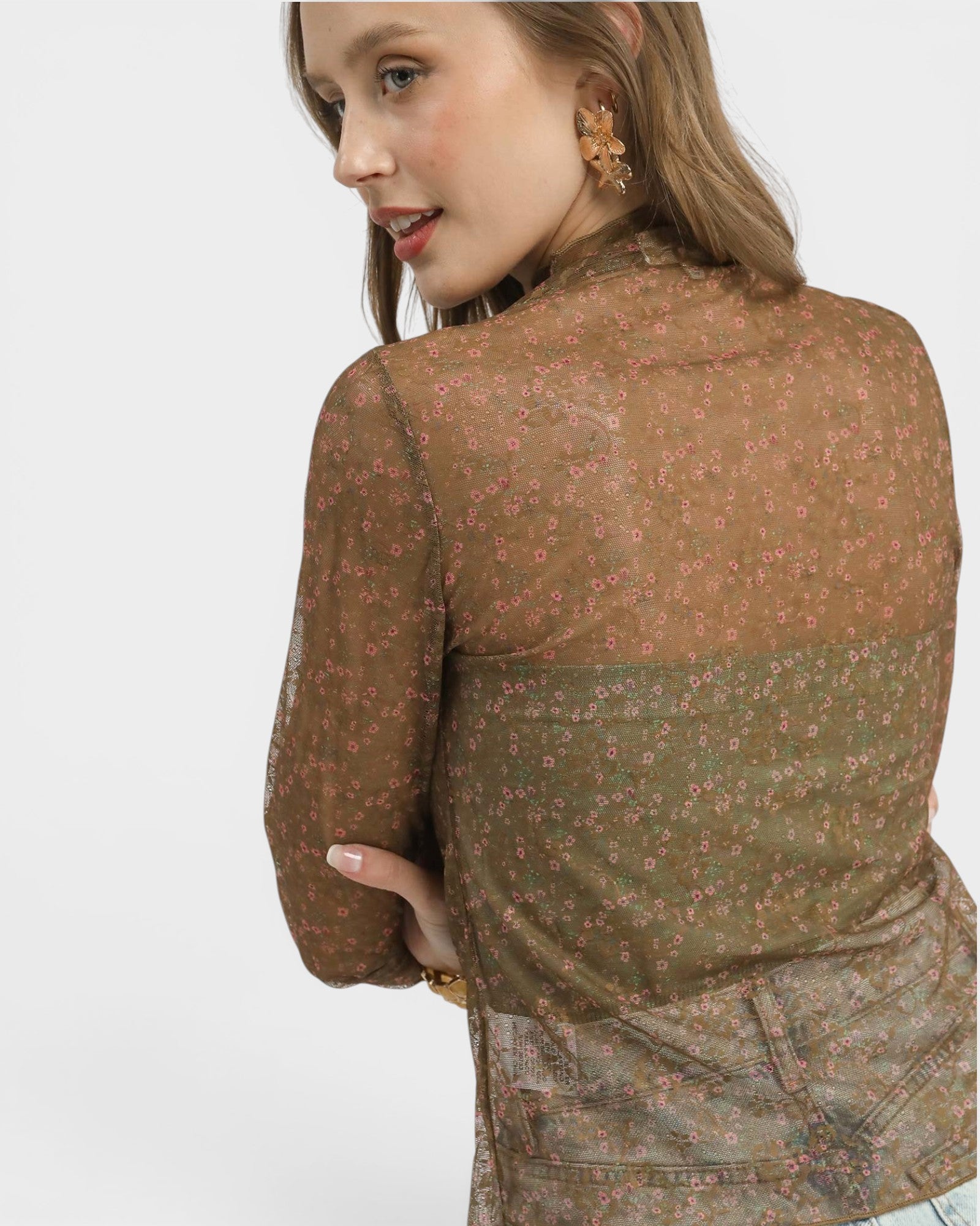 Woman wearing a brown floral blouse on a white background