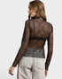 Woman wearing a sheer black lace top with a plain background